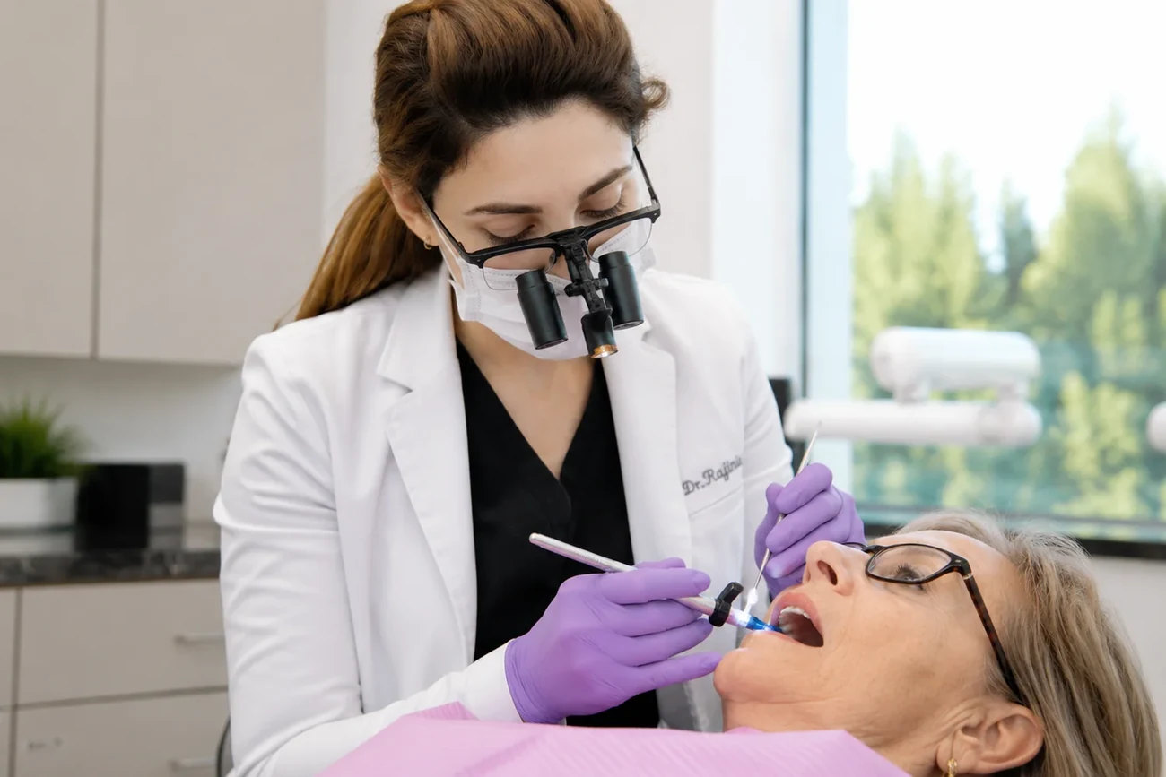 Dr. Mersedeh placing a tooth-colored restoration under magnification