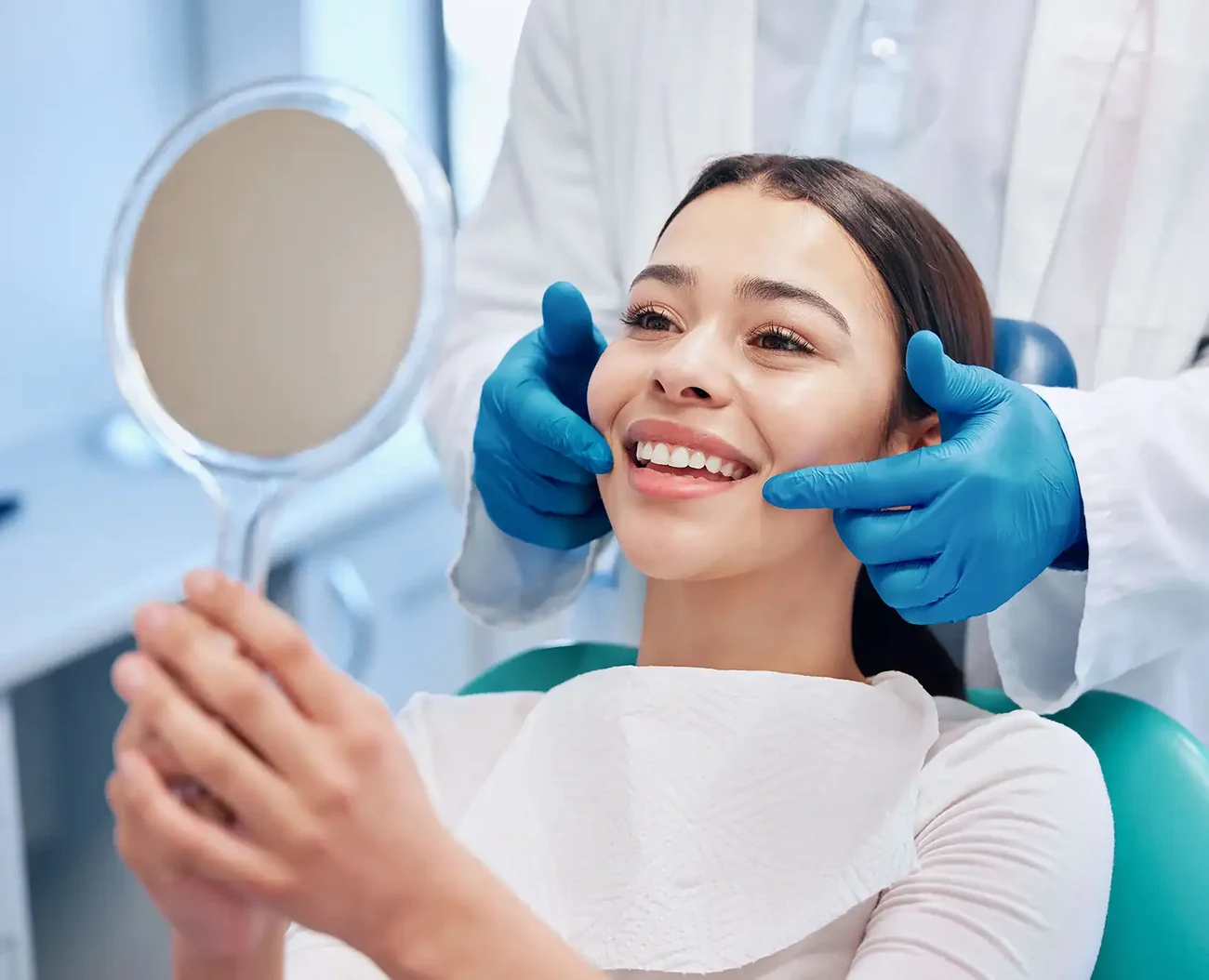 A patient admiring her natural, metal-free restorations in a mirror